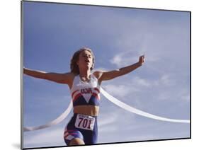 Female Runner Victorious at the Finish Line in a Track Race-null-Mounted Photographic Print