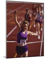 Female Runner Victorious at the Finish Line in a Track Race-null-Mounted Photographic Print