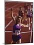 Female Runner Victorious at the Finish Line in a Track Race-null-Mounted Photographic Print