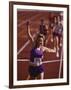 Female Runner Victorious at the Finish Line in a Track Race-null-Framed Photographic Print