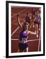 Female Runner Victorious at the Finish Line in a Track Race-null-Framed Photographic Print