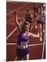 Female Runner Victorious at the Finish Line in a Track Race-null-Mounted Photographic Print