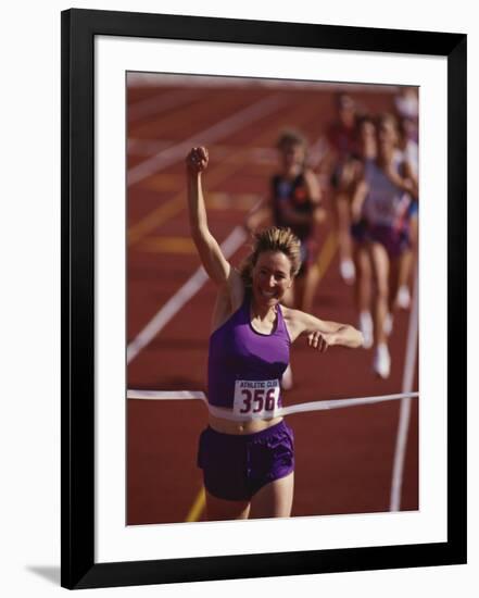 Female Runner Victorious at the Finish Line in a Track Race-null-Framed Photographic Print