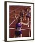 Female Runner Victorious at the Finish Line in a Track Race-null-Framed Photographic Print