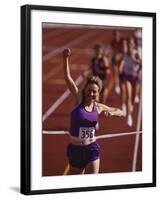 Female Runner Victorious at the Finish Line in a Track Race-null-Framed Photographic Print