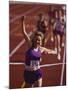 Female Runner Victorious at the Finish Line in a Track Race-null-Mounted Photographic Print