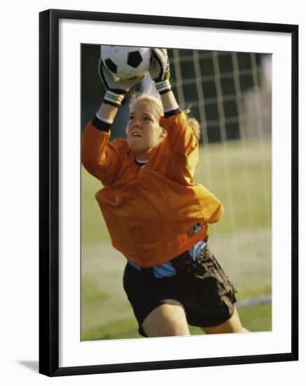Female Soccer Goalie Catching the Ball-null-Framed Photographic Print