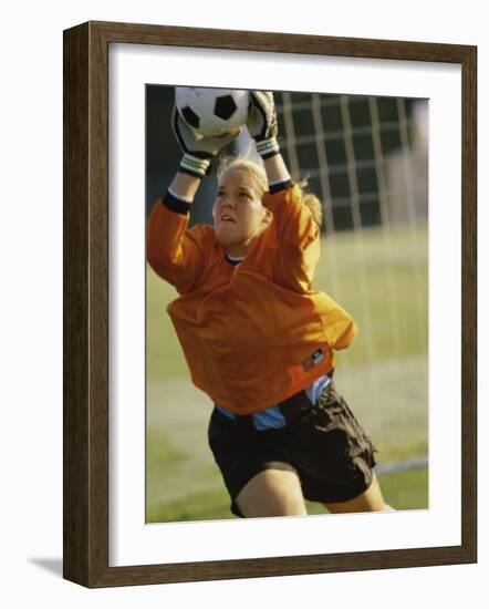 Female Soccer Goalie Catching the Ball-null-Framed Photographic Print