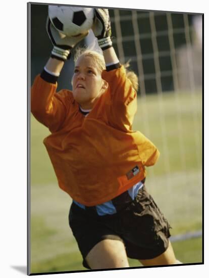 Female Soccer Goalie Catching the Ball-null-Mounted Photographic Print