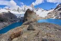 A couple in mountain gear rests on rocks with view to Lago de los Tres and Mount Fitz Roy, Patagoni-Fernando Carniel Machado-Photographic Print