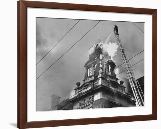 Fireman on Ladder Using a Hose to Extinguish Blazing Building Set Afire-Hans Wild-Framed Photographic Print