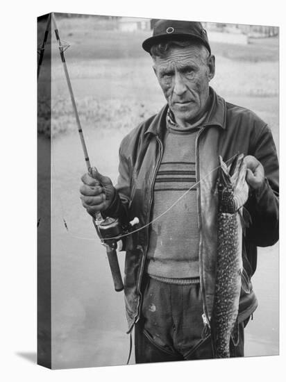 Fisherman Lauri Rapala, Who Handmakes Fishing Lures, with a Fish He Caught-null-Stretched Canvas