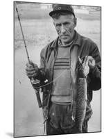 Fisherman Lauri Rapala, Who Handmakes Fishing Lures, with a Fish He Caught-null-Mounted Photographic Print