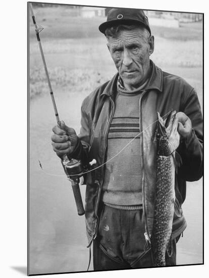 Fisherman Lauri Rapala, Who Handmakes Fishing Lures, with a Fish He Caught-null-Mounted Photographic Print