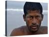 Fisherman Rests While Moving a Traditional Fishing Boat to the Sea at the Colva Beach in Goa, India-null-Stretched Canvas