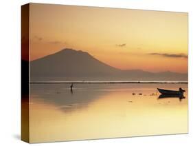 Fisherman Standing in Sea with Mount Agung in the Background, Sanur, Bali, Indonesia-Ian Trower-Stretched Canvas