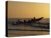 Fishermen Launch their Boat into the Atlantic Ocean at Sunset-Amar Grover-Stretched Canvas