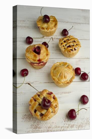 Five Freshly Baked Homemade Cherry Pies on a Rustic White Table Surrounded by a Few Fresh Cherries-Cynthia Classen-Stretched Canvas