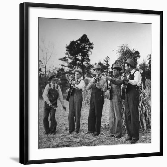 Five Male Musicians Dressed in Hats and Bib Overalls Standing in a Field-Eric Schaal-Framed Photographic Print