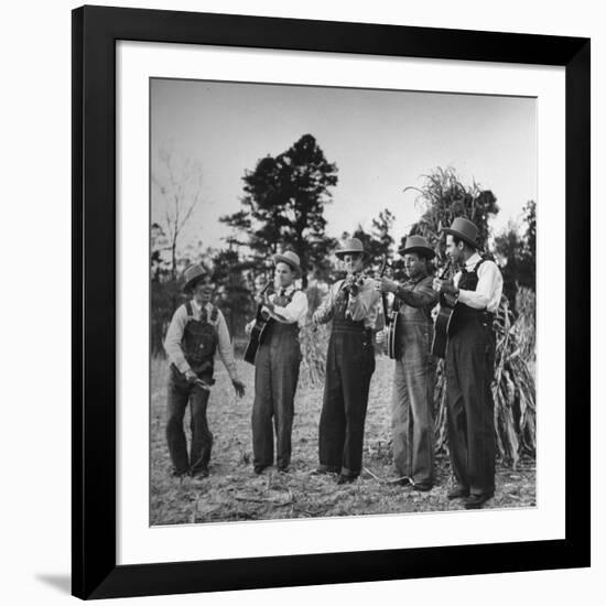 Five Male Musicians Dressed in Hats and Bib Overalls Standing in a Field-Eric Schaal-Framed Photographic Print