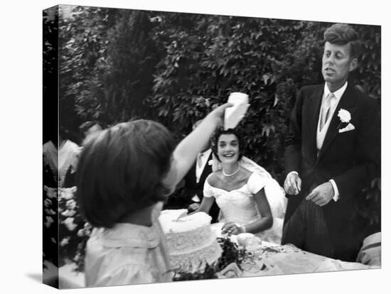 Flower Girl Janet Auchincloss Holding Up a Wedge of Wedding Cake for Bridegroom Sen. John Kennedy-Lisa Larsen-Stretched Canvas