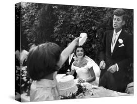 Flower Girl Janet Auchincloss Holding Up a Wedge of Wedding Cake for Bridegroom Sen. John Kennedy-Lisa Larsen-Stretched Canvas