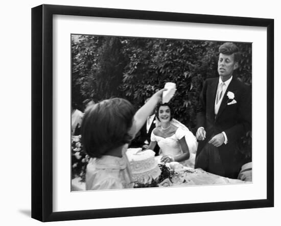 Flower Girl Janet Auchincloss Holding Up a Wedge of Wedding Cake for Bridegroom Sen. John Kennedy-Lisa Larsen-Framed Photographic Print