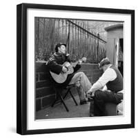 Folk Singer Woody Guthrie Palying His Guitar While Getting a Shoeshine-null-Framed Premium Photographic Print
