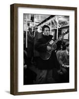 Folk Singer Woody Guthrie Singing Aboard a Subway Train-null-Framed Premium Photographic Print