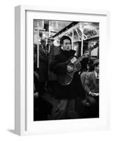 Folk Singer Woody Guthrie Singing Aboard a Subway Train-null-Framed Premium Photographic Print