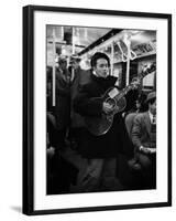 Folk Singer Woody Guthrie Singing Aboard a Subway Train-null-Framed Premium Photographic Print