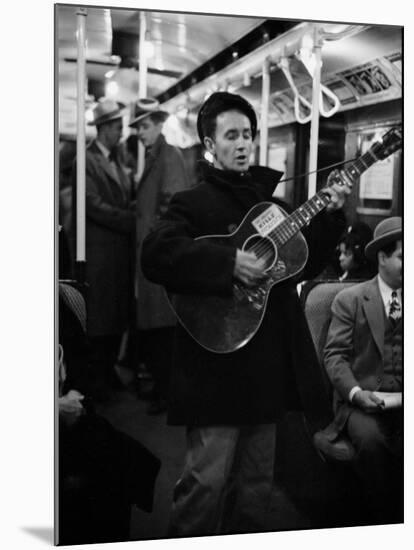 Folk Singer Woody Guthrie Singing Aboard a Subway Train-null-Mounted Premium Photographic Print