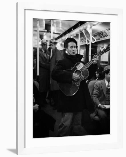 Folk Singer Woody Guthrie Singing Aboard a Subway Train-null-Framed Premium Photographic Print