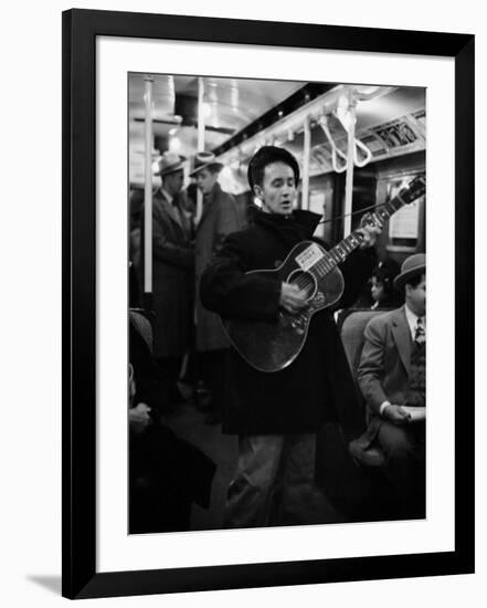 Folk Singer Woody Guthrie Singing Aboard a Subway Train-null-Framed Premium Photographic Print