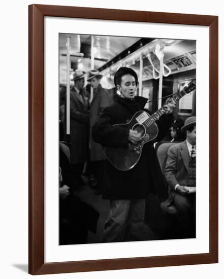 Folk Singer Woody Guthrie Singing Aboard a Subway Train-null-Framed Premium Photographic Print