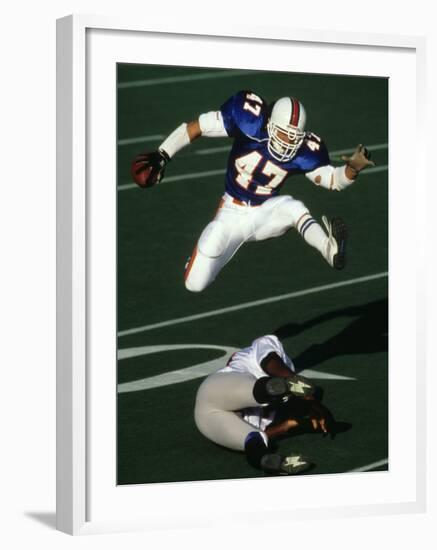 Football Running Back Flys over the Defense-null-Framed Photographic Print