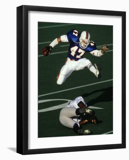 Football Running Back Flys over the Defense-null-Framed Photographic Print