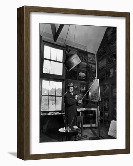 Former PM Winston Churchill Smoking a Cigar in His Studio Dressed in His Blue RAF Siren Jump Suit-Hans Wild-Framed Photographic Print