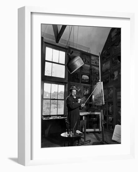 Former PM Winston Churchill Smoking a Cigar in His Studio Dressed in His Blue RAF Siren Jump Suit-Hans Wild-Framed Photographic Print