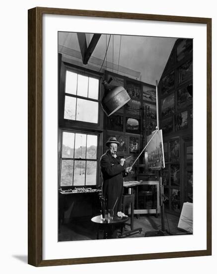 Former PM Winston Churchill Smoking a Cigar in His Studio Dressed in His Blue RAF Siren Jump Suit-Hans Wild-Framed Photographic Print