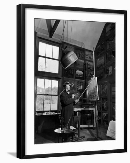 Former PM Winston Churchill Smoking a Cigar in His Studio Dressed in His Blue RAF Siren Jump Suit-Hans Wild-Framed Photographic Print