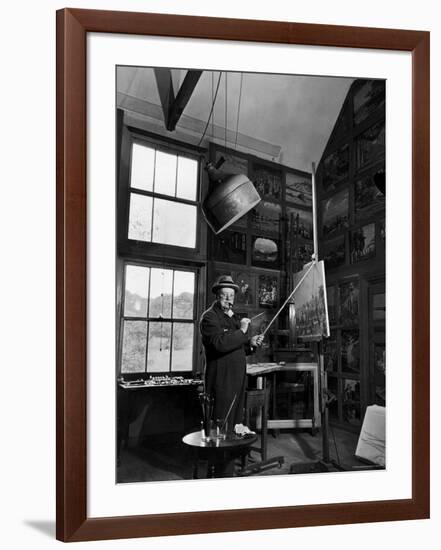 Former PM Winston Churchill Smoking a Cigar in His Studio Dressed in His Blue RAF Siren Jump Suit-Hans Wild-Framed Photographic Print