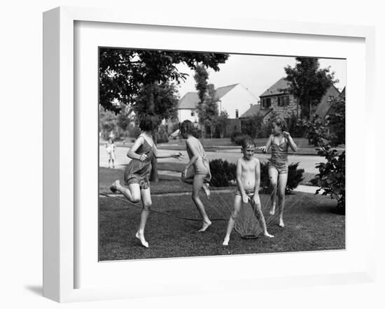 Four Children in Bathing Suits Playing with Water Sprinkler and Running Through Spray on Front Lawn-Alfred Eisenstaedt-Framed Photographic Print