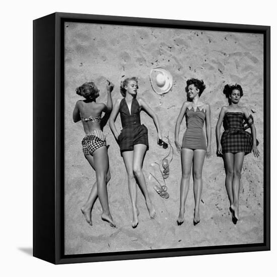 Four Models Showing Off the Latest Bathing Suit Fashions While Lying on a Sandy Florida Beach-Nina Leen-Framed Stretched Canvas