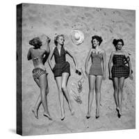 Four Models Showing Off the Latest Bathing Suit Fashions While Lying on a Sandy Florida Beach-Nina Leen-Stretched Canvas