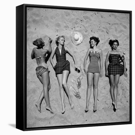 Four Models Showing Off the Latest Bathing Suit Fashions While Lying on a Sandy Florida Beach-Nina Leen-Framed Stretched Canvas