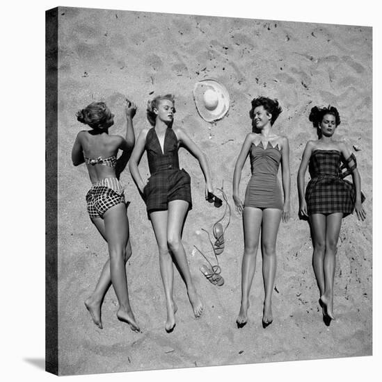 Four Models Showing Off the Latest Bathing Suit Fashions While Lying on a Sandy Florida Beach-Nina Leen-Stretched Canvas