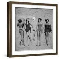 Four Models Showing Off the Latest Bathing Suit Fashions While Lying on a Sandy Florida Beach-Nina Leen-Framed Photographic Print