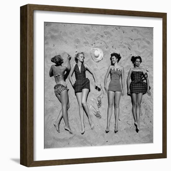 Four Models Showing Off the Latest Bathing Suit Fashions While Lying on a Sandy Florida Beach-Nina Leen-Framed Photographic Print