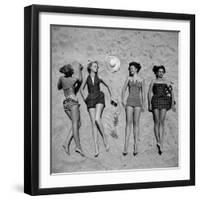 Four Models Showing Off the Latest Bathing Suit Fashions While Lying on a Sandy Florida Beach-Nina Leen-Framed Photographic Print